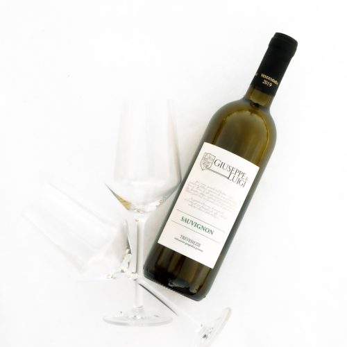 white labeled bottle beside clear wine glass